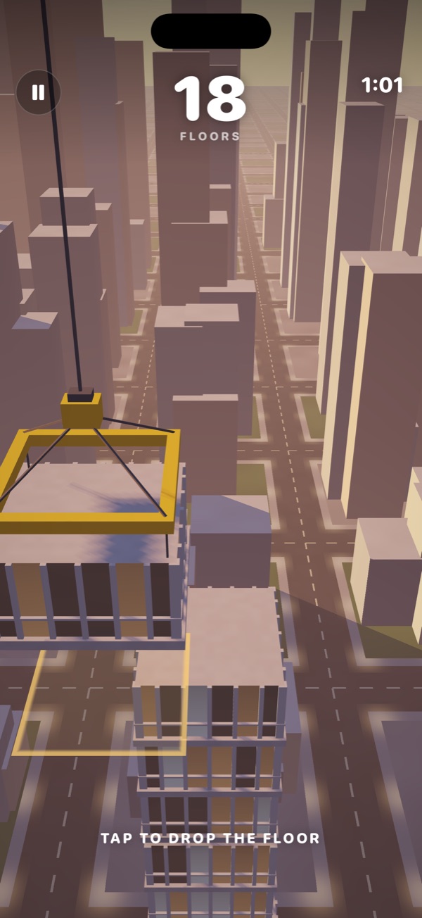 A glass tower rising over the city at sunset while the crane lowers the next floor